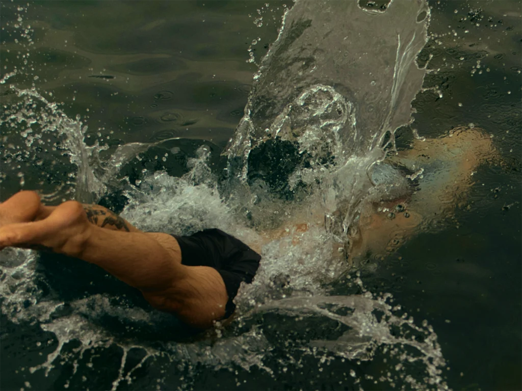 Person diving into water creating a large splash.