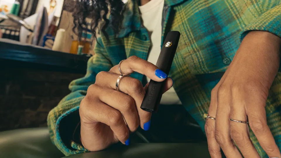 Skip the Smoke: Discreet Cannabis for Family Gatherings 2 Person holding a vape pen.