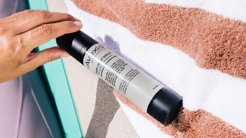 cannabis topical bottle on a towel by the pool