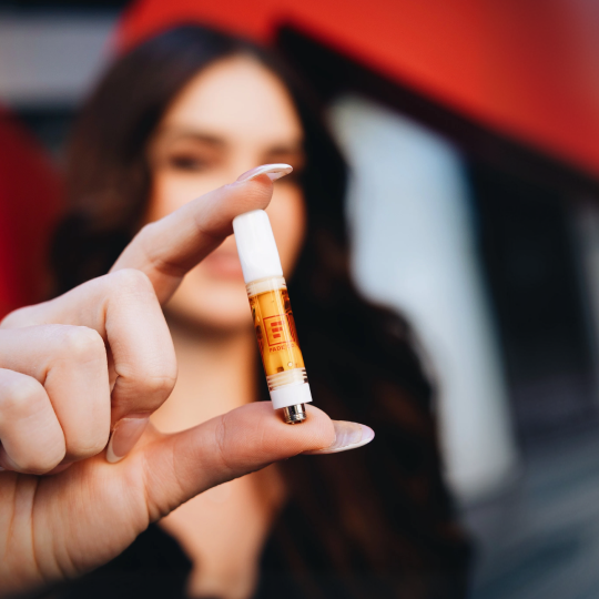 Person holding a vape cartridge.