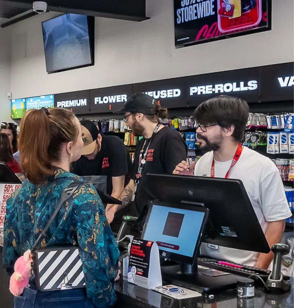 Story Cannabis budtenders helping customers at the checkout counter inside the Phoenix dispensary.