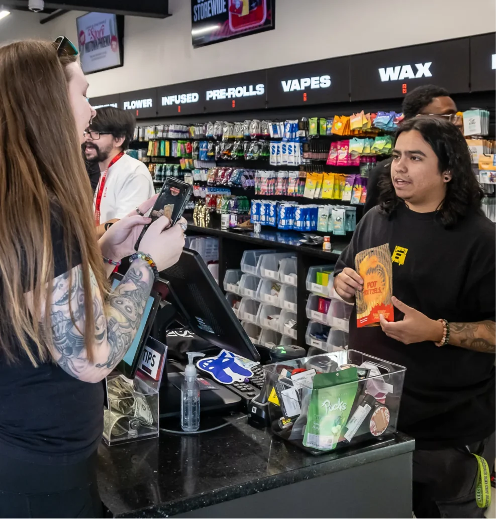 Story Cannabis budtender assisting a customer and presenting cannabis products at the sales counter.